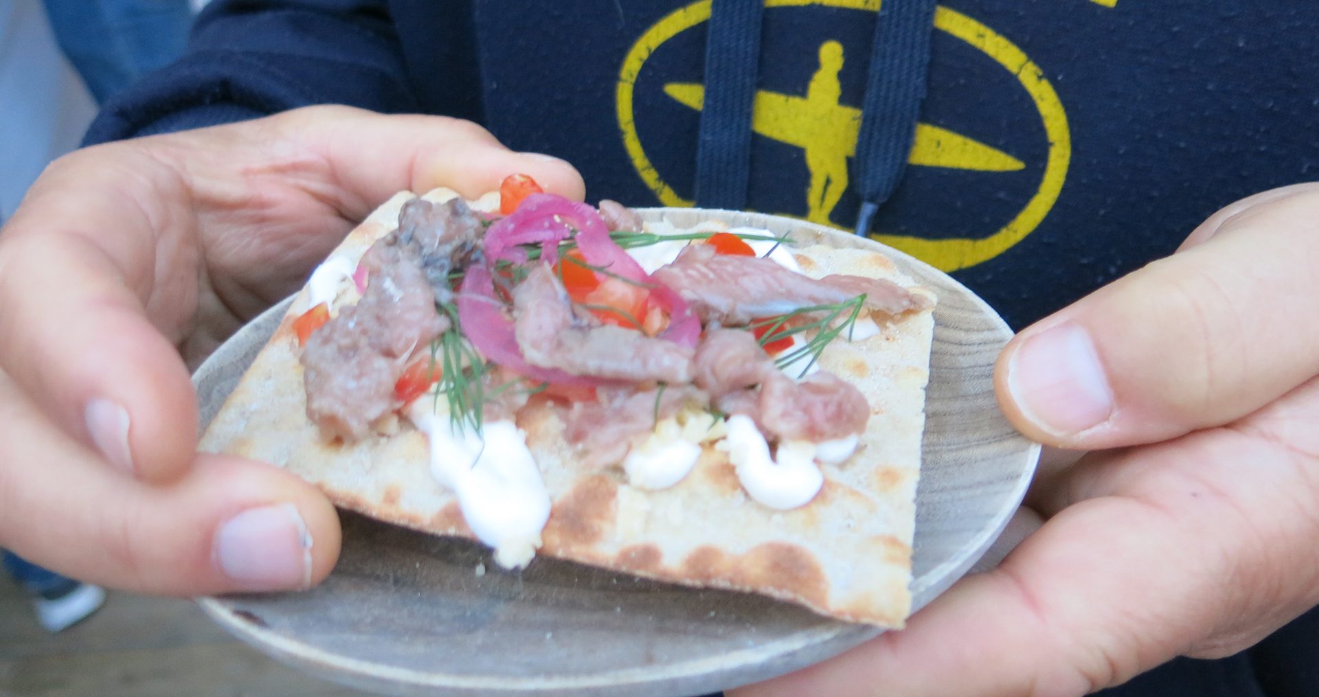 Fermented herring on a bit of bread, with red onion and dill