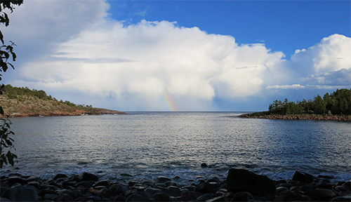 A rainbow visible on the ocean 